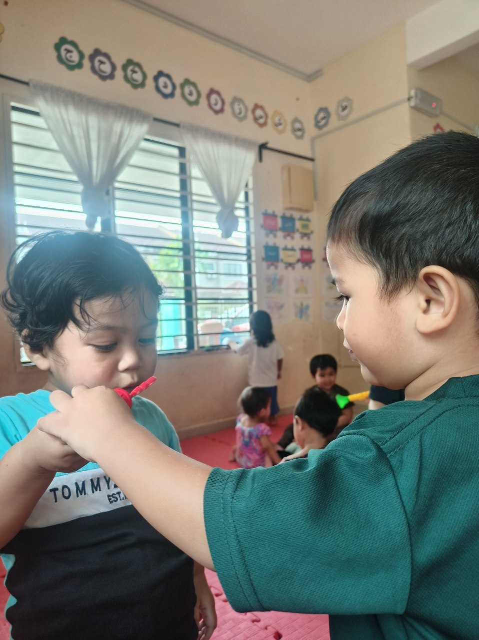 Dua kanak-kanak bermain buih sabun bersama.